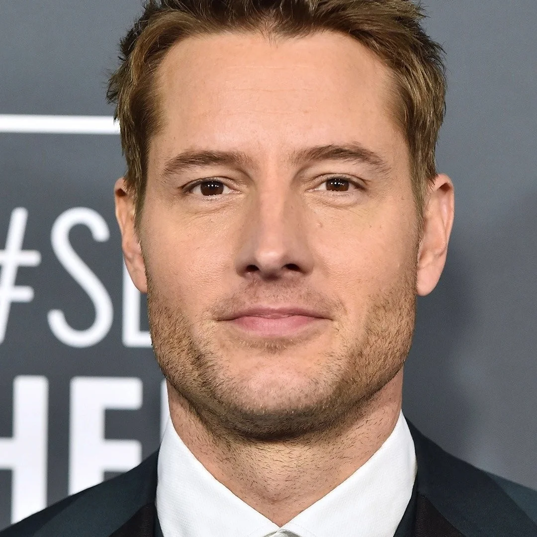 Justin Hartley at an event, looking directly at the camera.