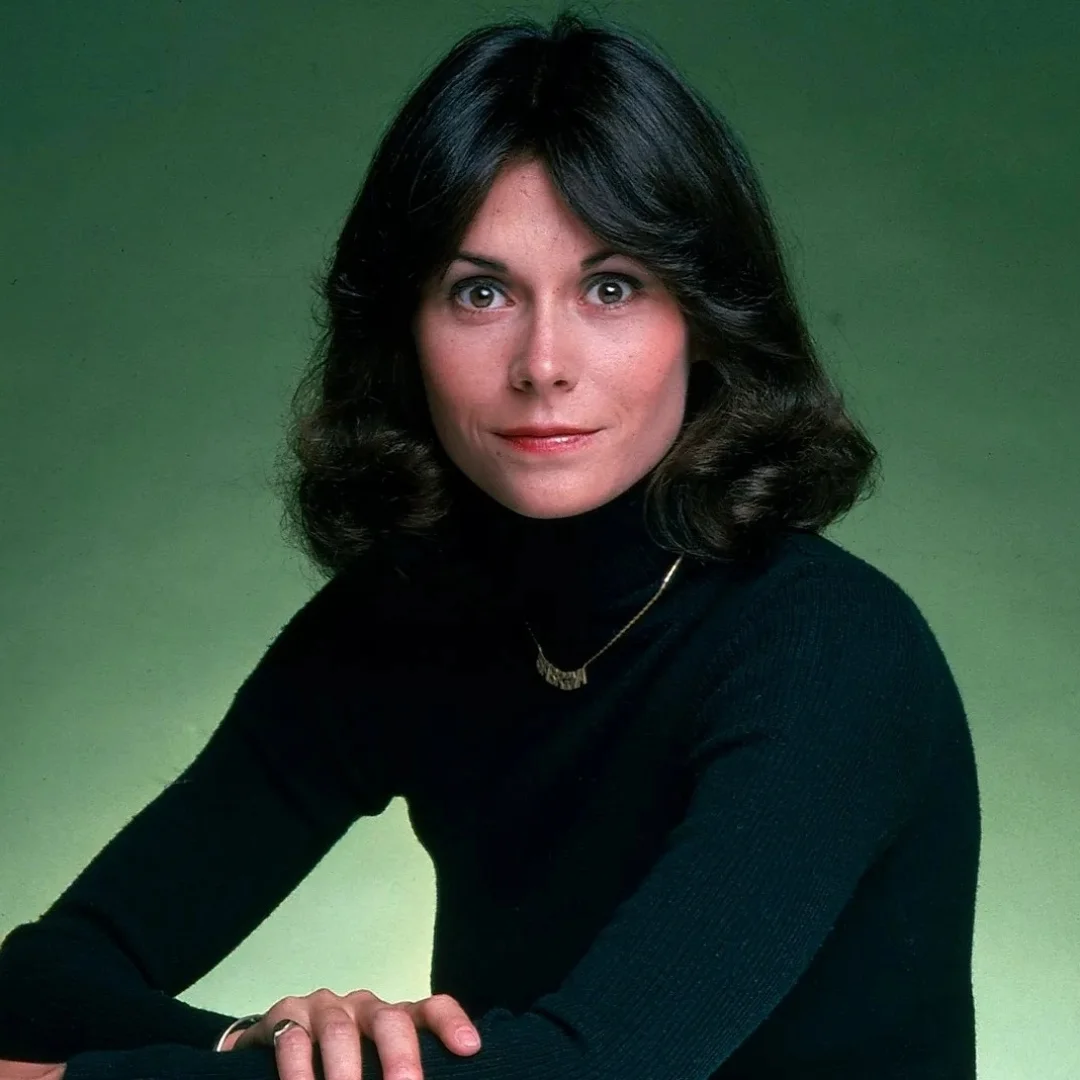 Kate Jackson, American actress posing in a black turtleneck with a green background.