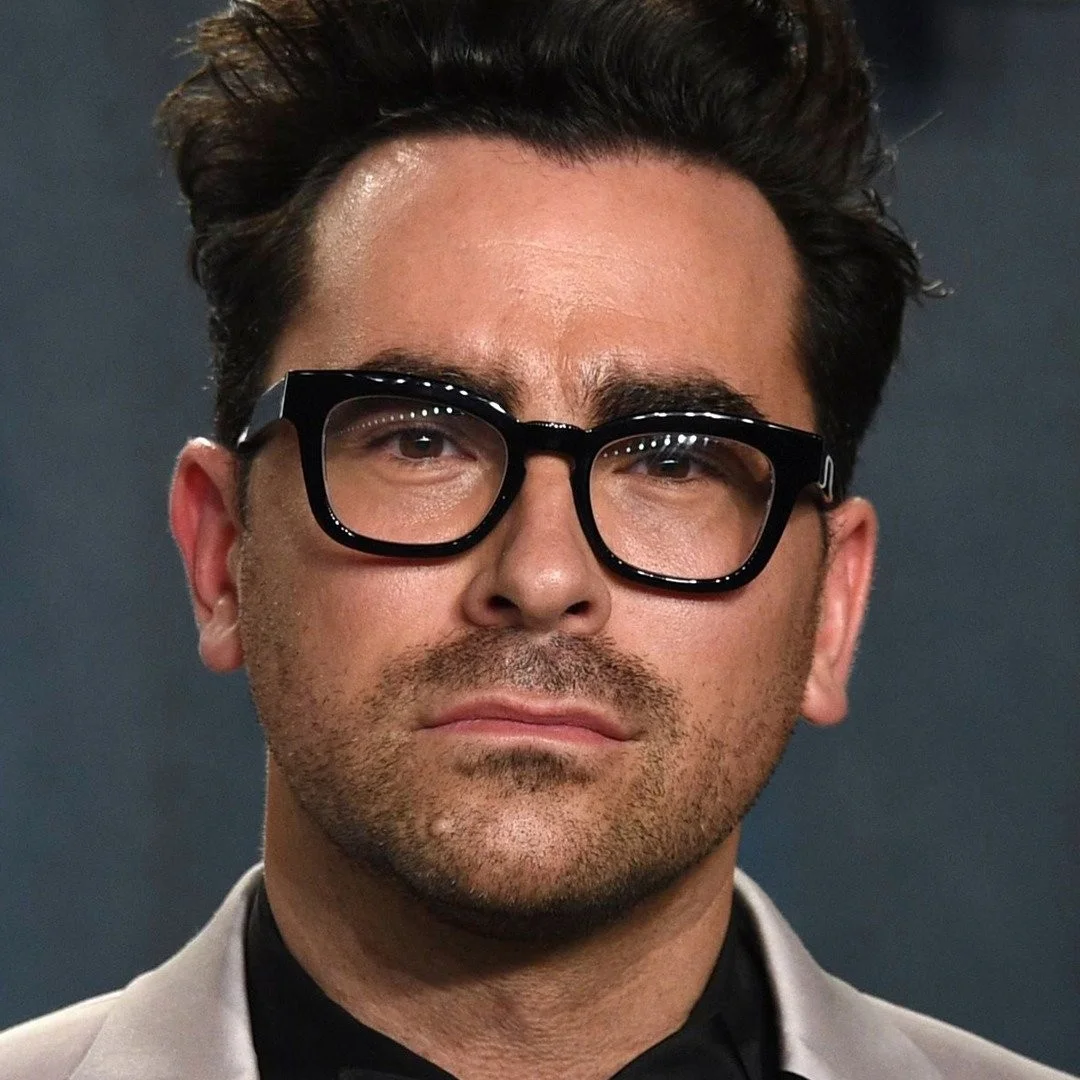 Dan Levy, Canadian actor and creator wearing black-framed glasses and a suit at an event