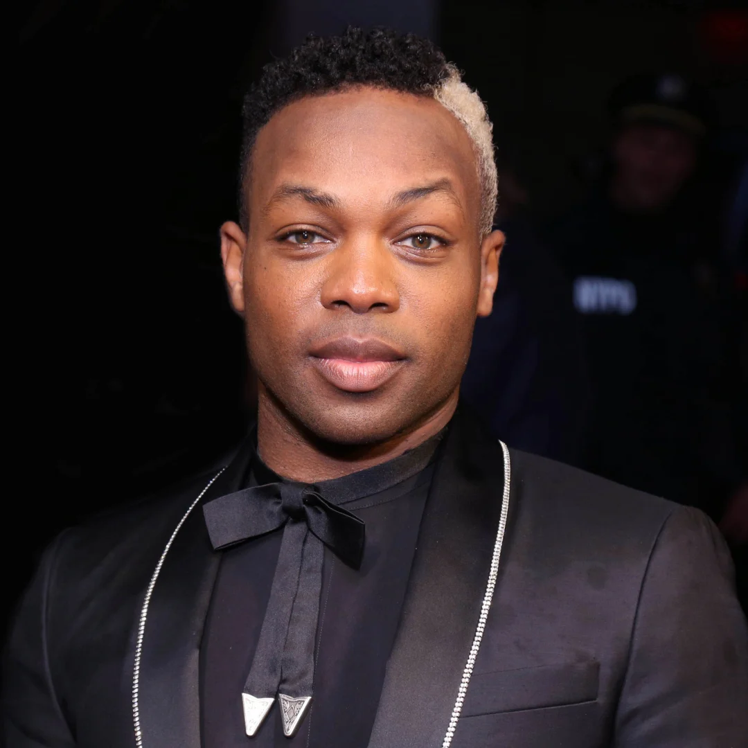 Todrick Hall, American singer, actor, and choreographer, wearing a black suit with a bow tie at a formal event.