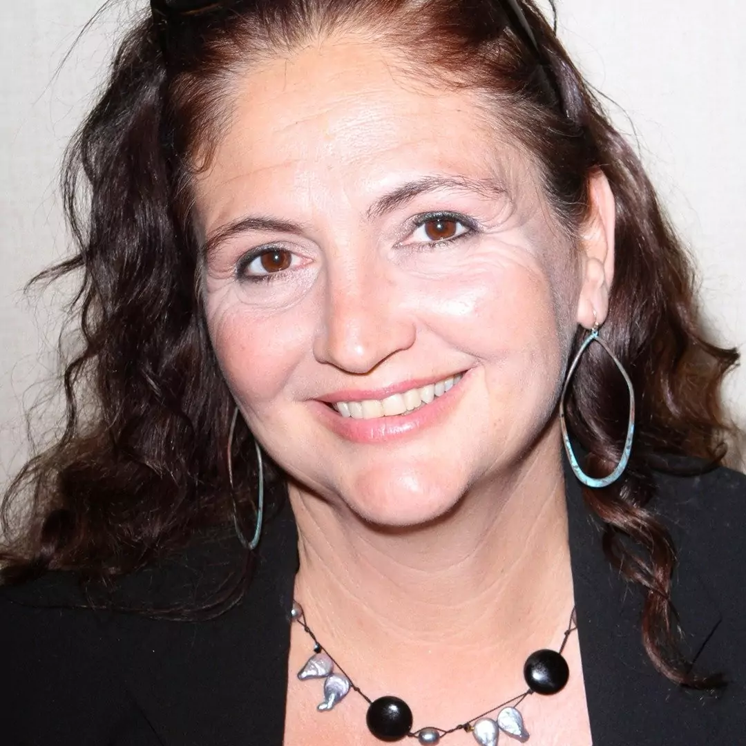 Tracy Reiner smiling at a public event, highlighting her career as a Hollywood actress.